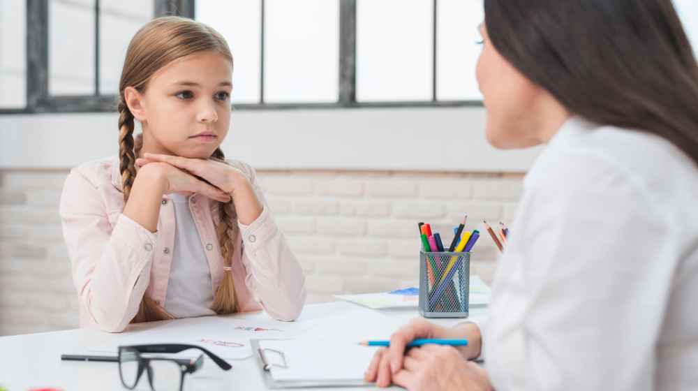 Freepik Assets "Free photo young child psychologist talking with sad little girl in the office"